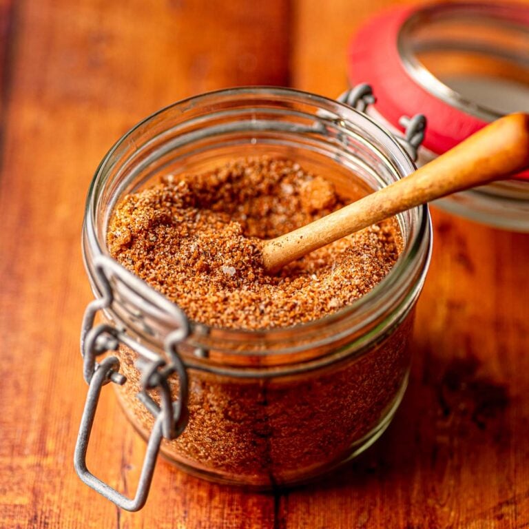 Homemade BBQ spice rub in a glass jar, packed with rich, smoky color and texture.