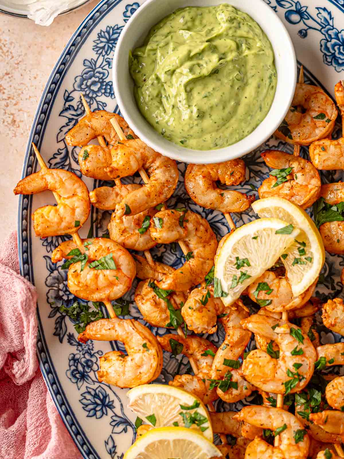 Juicy shrimp on skewers with smoky char, garnished with herbs and lemon.