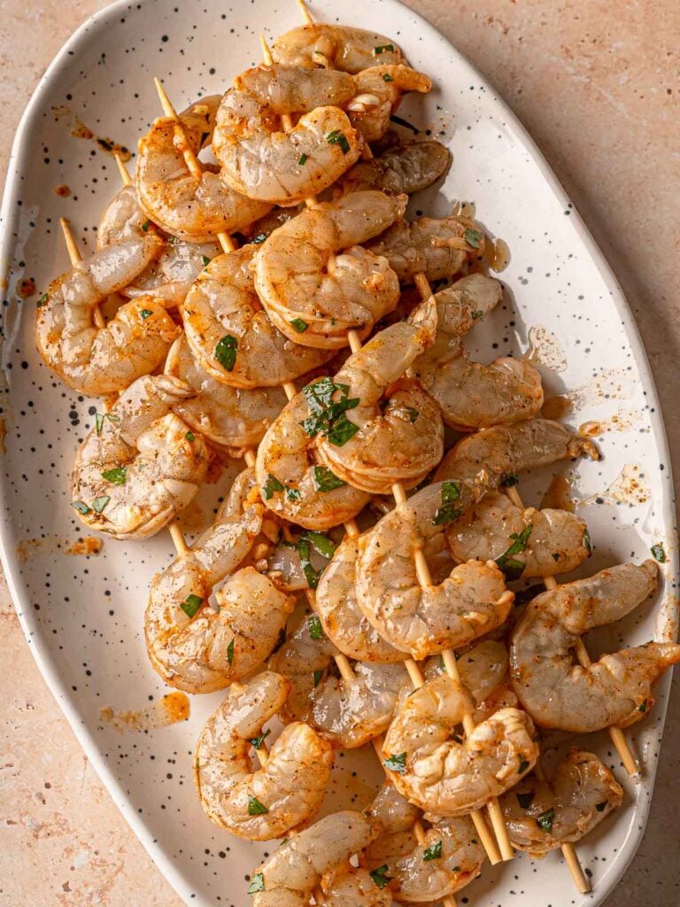Marinated shrimp threaded onto wooden skewers.