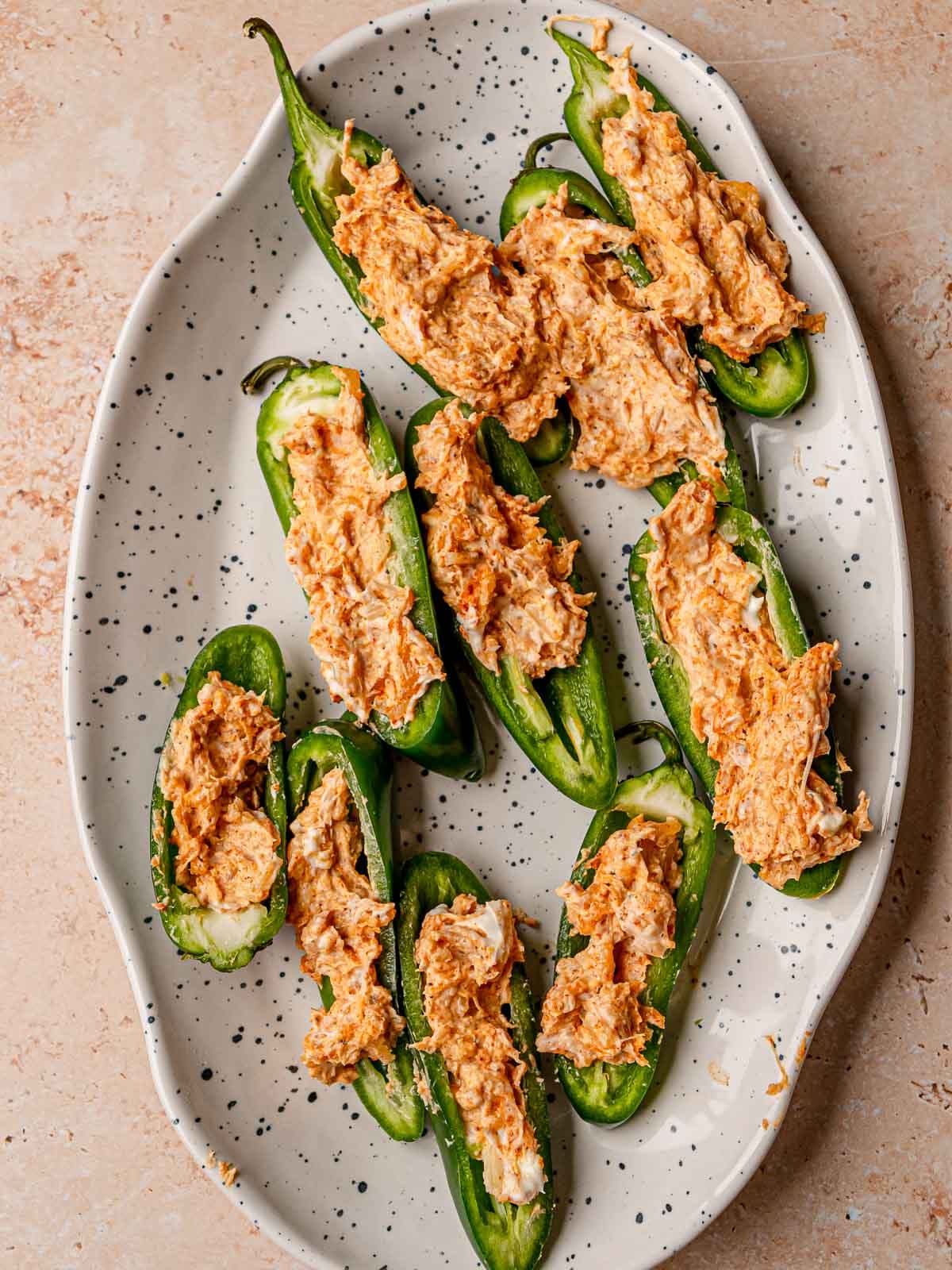 Jalapeño halves filled with a creamy cheese mixture and arranged on a serving platter.