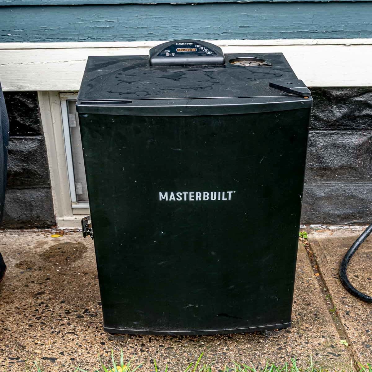 Masterbuilt electric smoker set up on an outdoor patio.