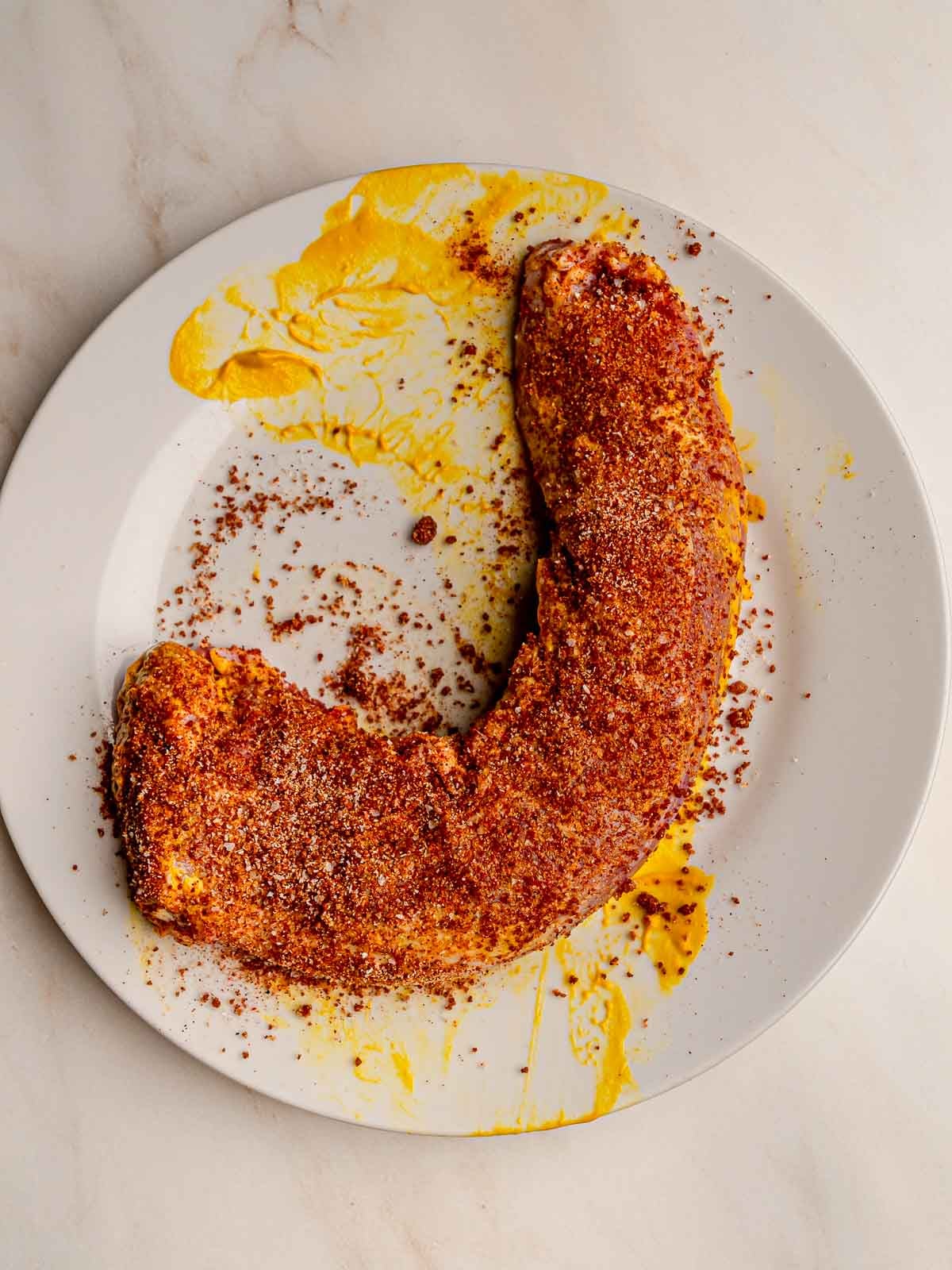 Pork tenderloin covered in BBQ rub and ready for the smoker.